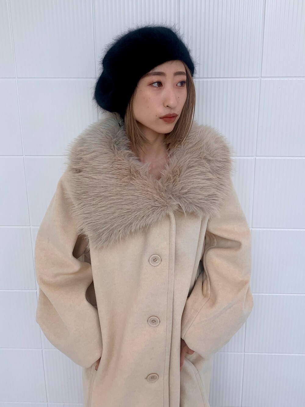 ホワイト系のピーコート、その他のブーツ、ブラック系のハンチング/ベレー帽を着用したレディースの冬コーディネートの4枚目の写真