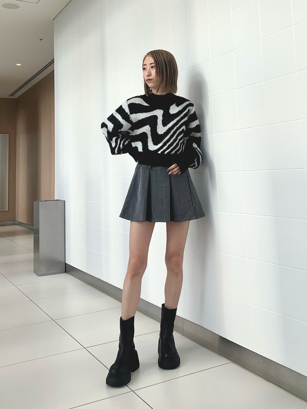 ブラック系のニット/セーター、ブラック系のブルゾン、ブラック系のブーツを着用したレディースの冬コーディネートの5枚目の写真