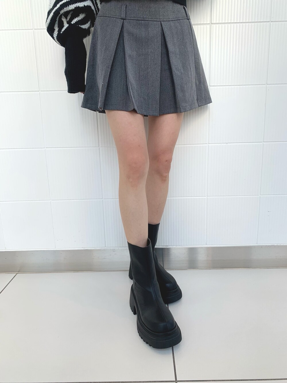 ブラック系のニット/セーター、ブラック系のブルゾン、ブラック系のブーツを着用したレディースの冬コーディネートの9枚目の写真