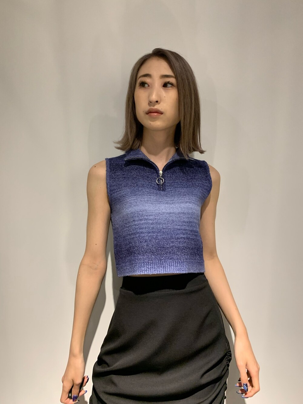 ブルー系のタンクトップ、ブラック系のスカート、ブラック系のサンダルを着用したレディースの春コーディネートの8枚目の写真