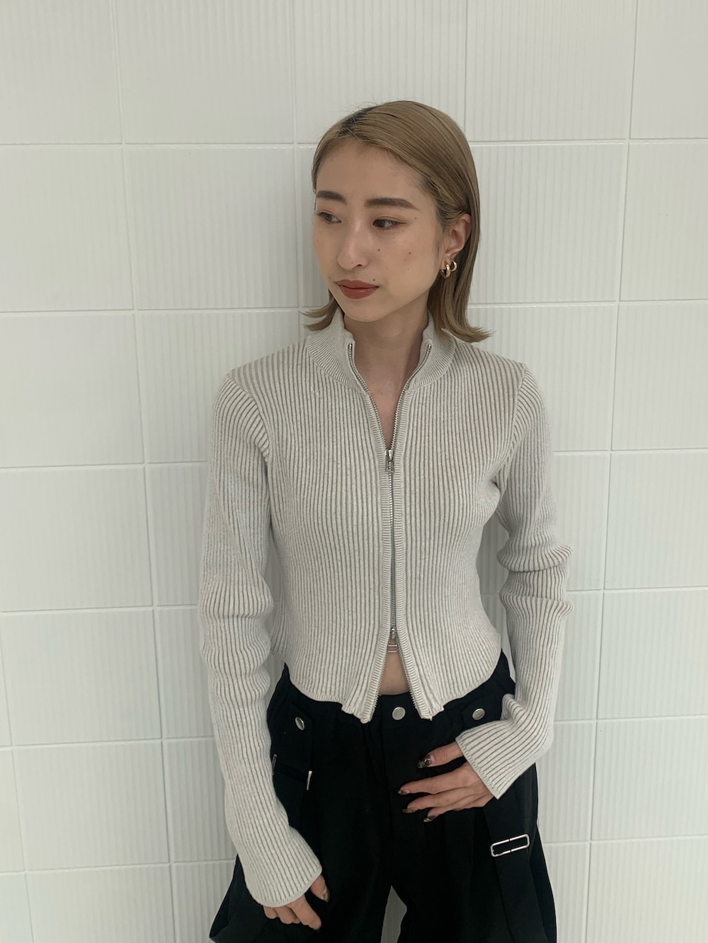 ブラック系のその他パンツ、ホワイト系のニット/セーター、ホワイト系のスニーカーを着用したレディースの冬コーディネートの3枚目の写真