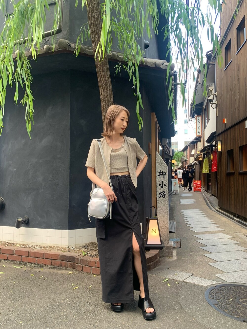 その他のアンサンブル、ブラック系のスカート、ブラック系のサンダルを着用したレディースの春コーディネートの2枚目の写真