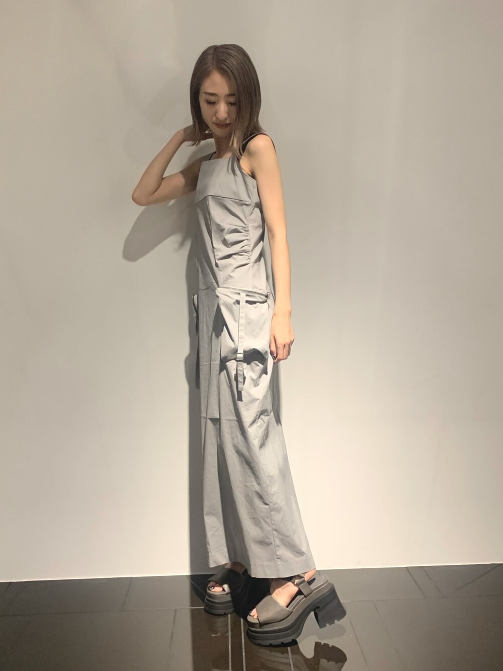 グレー系のワンピース、グレー系のサンダル、ブラック系のタンクトップを着用したレディースの夏コーディネートの3枚目の写真