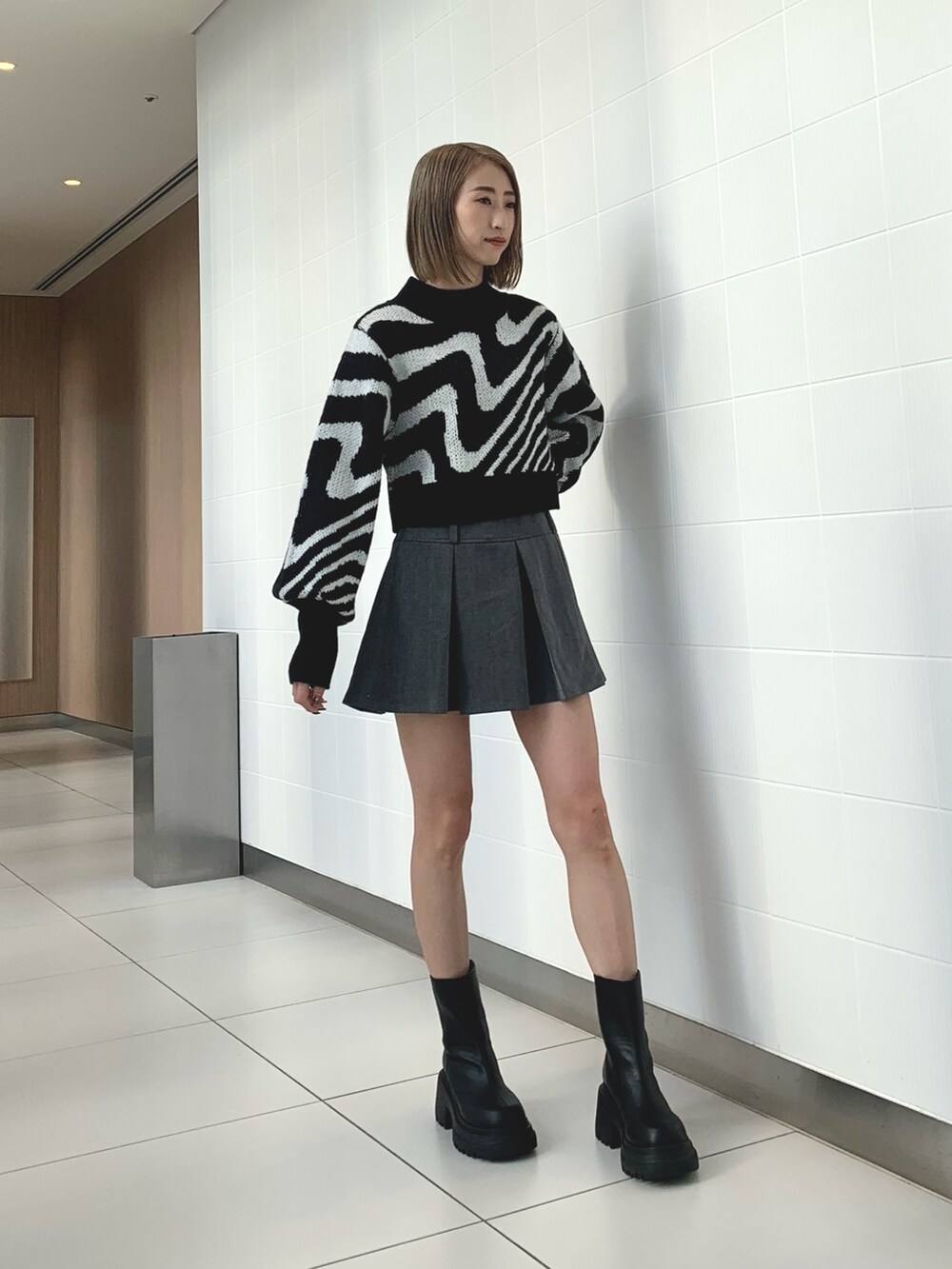 ブラック系のニット/セーター、ブラック系のブルゾン、ブラック系のブーツを着用したレディースの冬コーディネートの6枚目の写真