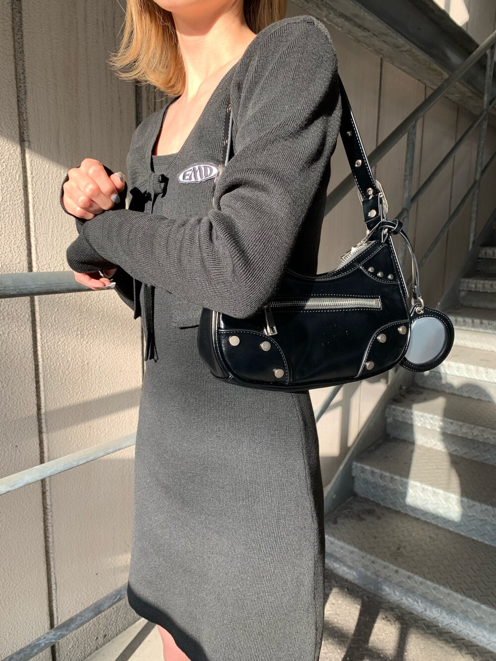 ブラック系のワンピース、ブラック系のサンダル、ブラック系のハンドバッグを着用したレディースの春コーディネートの5枚目の写真