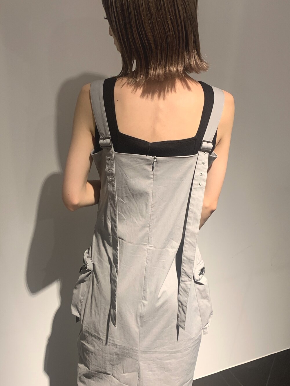 グレー系のワンピース、グレー系のサンダル、ブラック系のタンクトップを着用したレディースの夏コーディネートの8枚目の写真