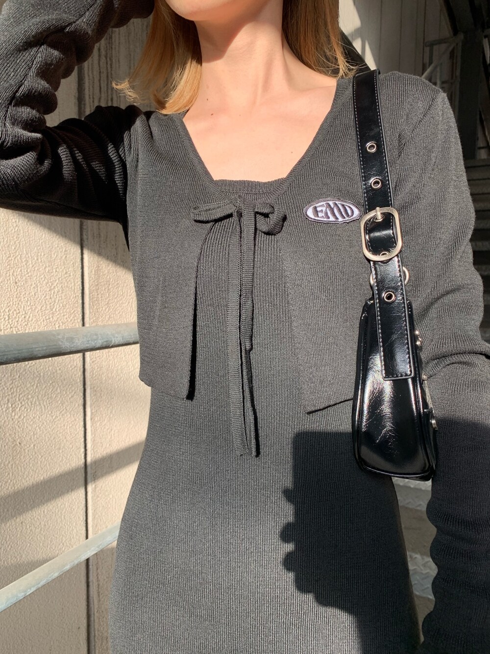 ブラック系のワンピース、ブラック系のサンダル、ブラック系のハンドバッグを着用したレディースの春コーディネートの6枚目の写真