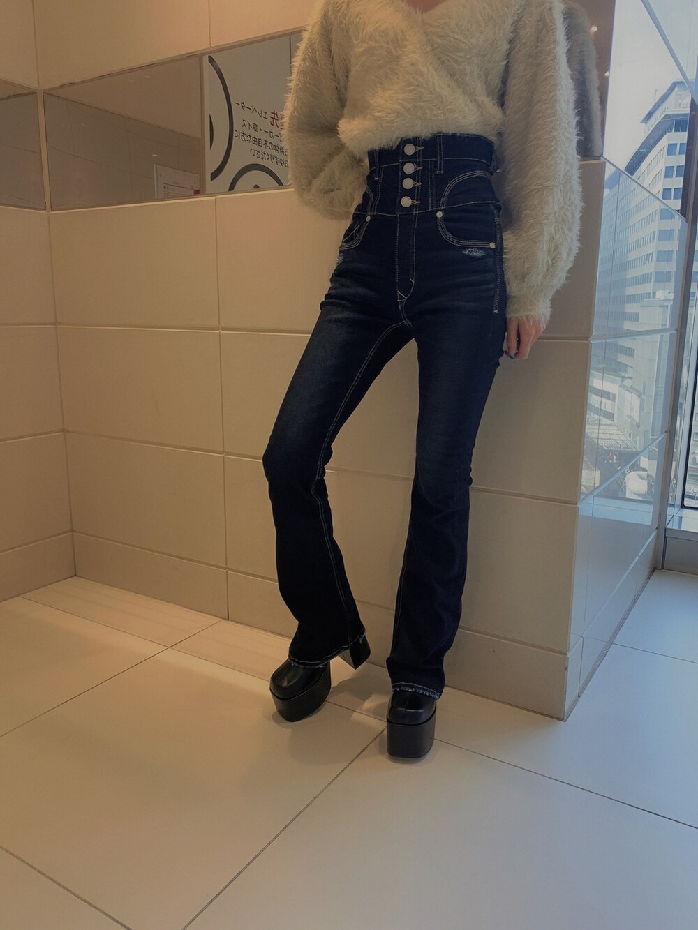 グレー系のニット/セーター、ブルー系のデニムパンツ、ブラック系のブーツを着用したレディースの冬コーディネートの9枚目の写真