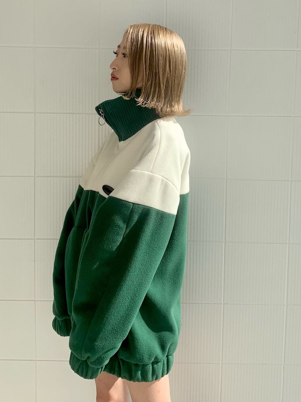 グリーン系のブルゾン、ブラック系のハンドバッグ、ブラック系のブーツを着用したレディースの秋コーディネートの4枚目の写真