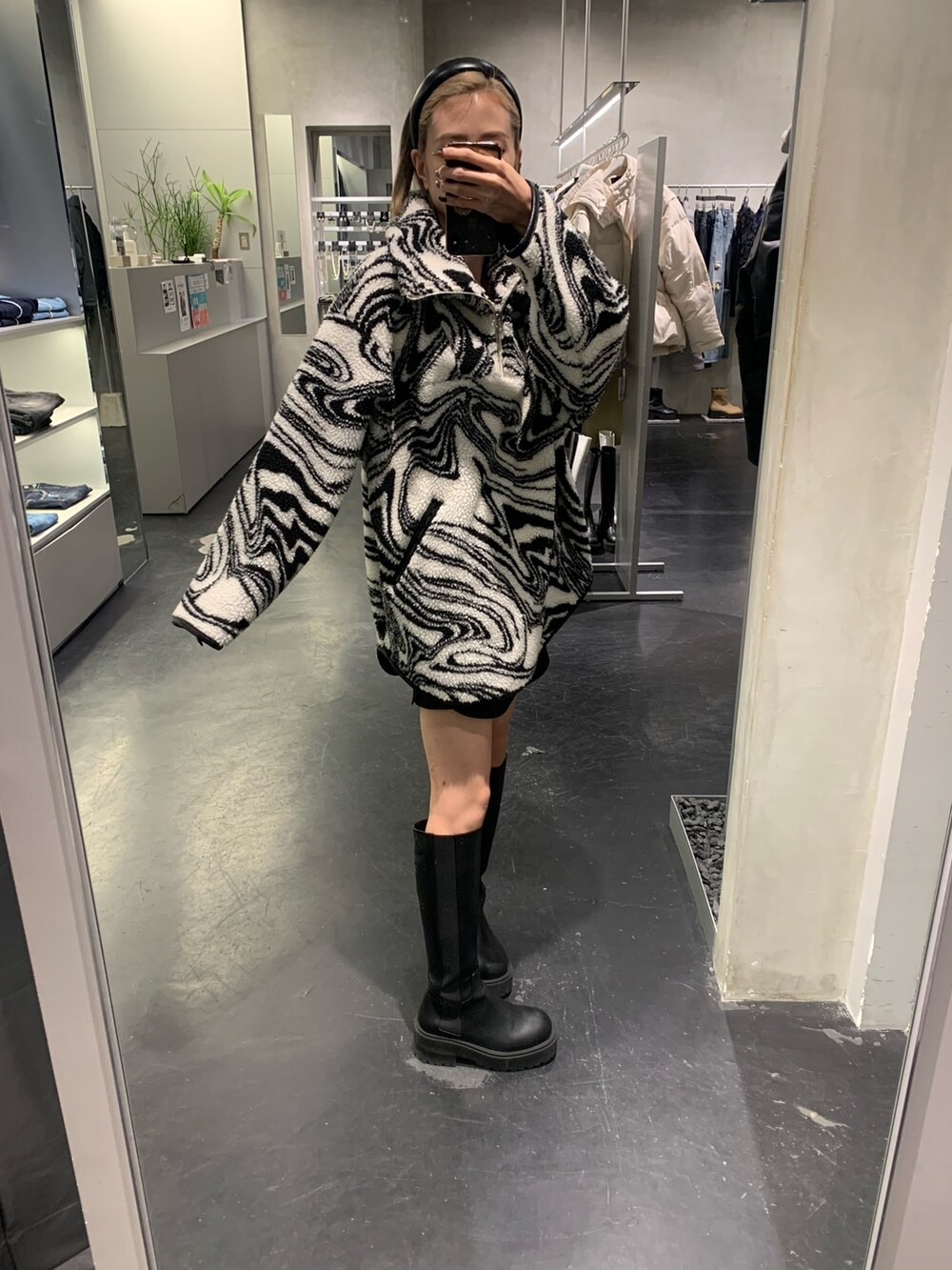 ブラック系のTシャツ/カットソー、ブラック系のブーツ、ブラック系のスカートを着用したレディースの秋コーディネートの2枚目の写真