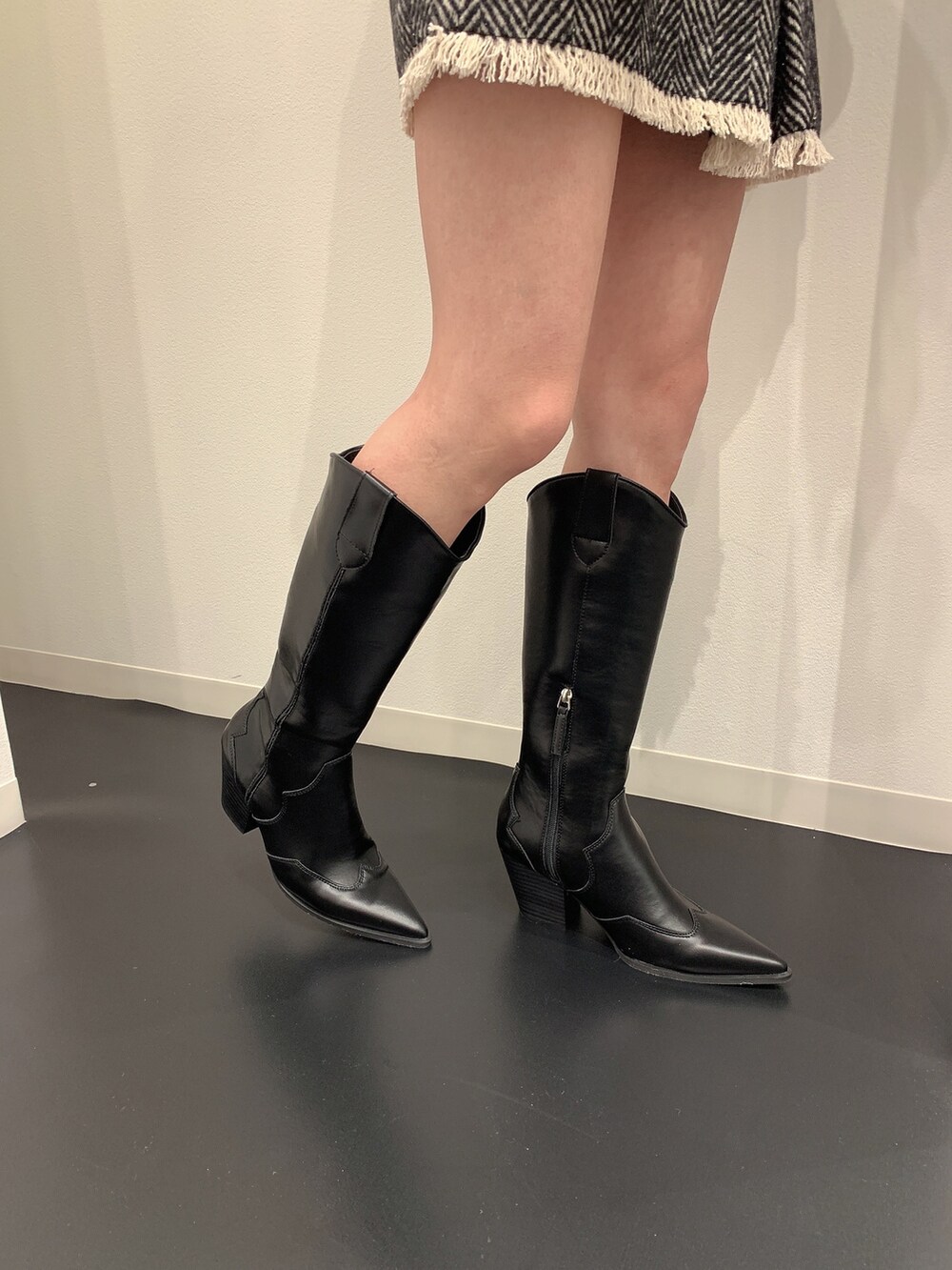 ブラック系のニット/セーター、ブラック系のブーツを着用したレディースの冬コーディネートの9枚目の写真