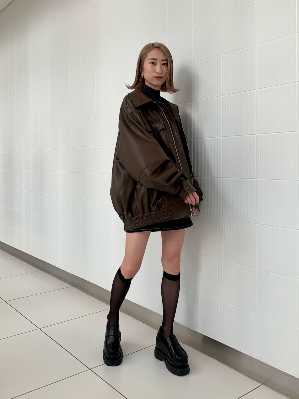 ブラウン系のブルゾン、その他のニット/セーター、ブラック系のスカートを着用したレディースの冬コーディネートの3枚目の写真