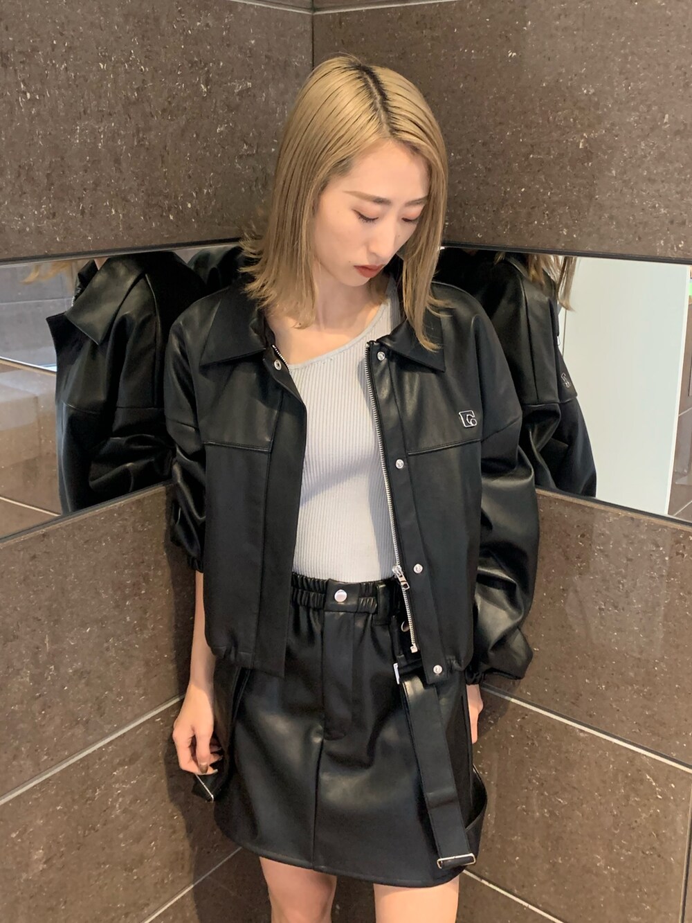 ブラック系のスカート、ブラック系のブルゾン、グレー系のニット/セーターを着用したレディースの冬コーディネートの3枚目の写真