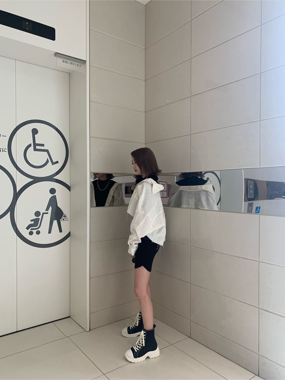 ホワイト系のブルゾン、ブラック系のスニーカー、ブラック系のワンピースを着用したレディースの春コーディネートの3枚目の写真