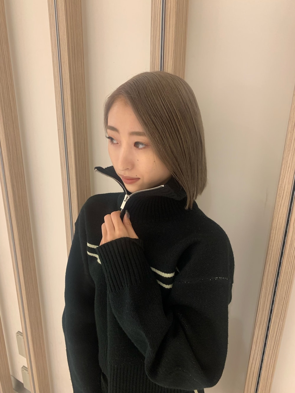 ブラック系のニット/セーター、ブラック系のスカート、ブラック系のブーツを着用したレディースの秋コーディネートの4枚目の写真