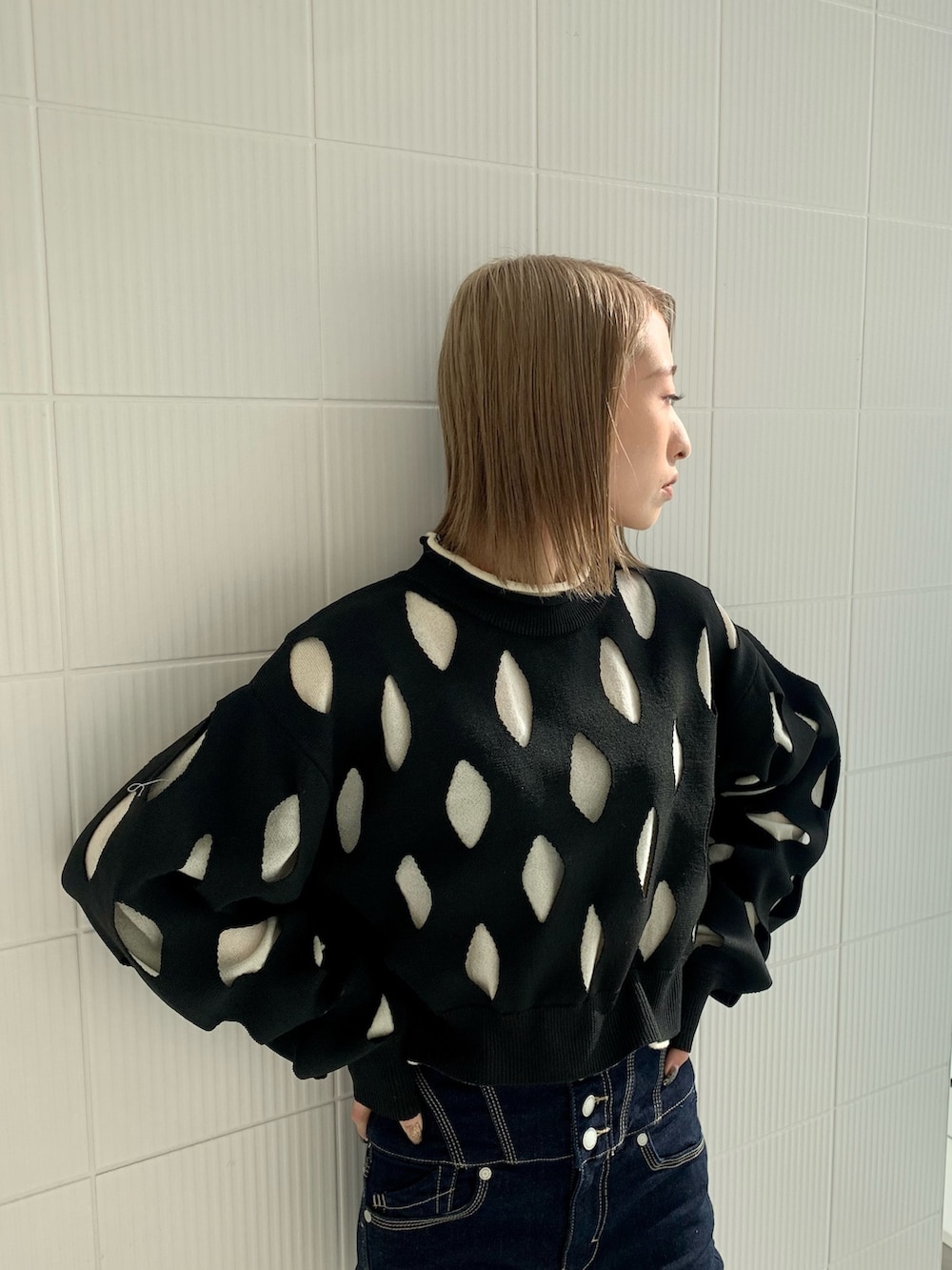 ブルー系のデニムパンツ、ブラック系のニット/セーター、ブラック系のブーツを着用したレディースの冬コーディネートの2枚目の写真