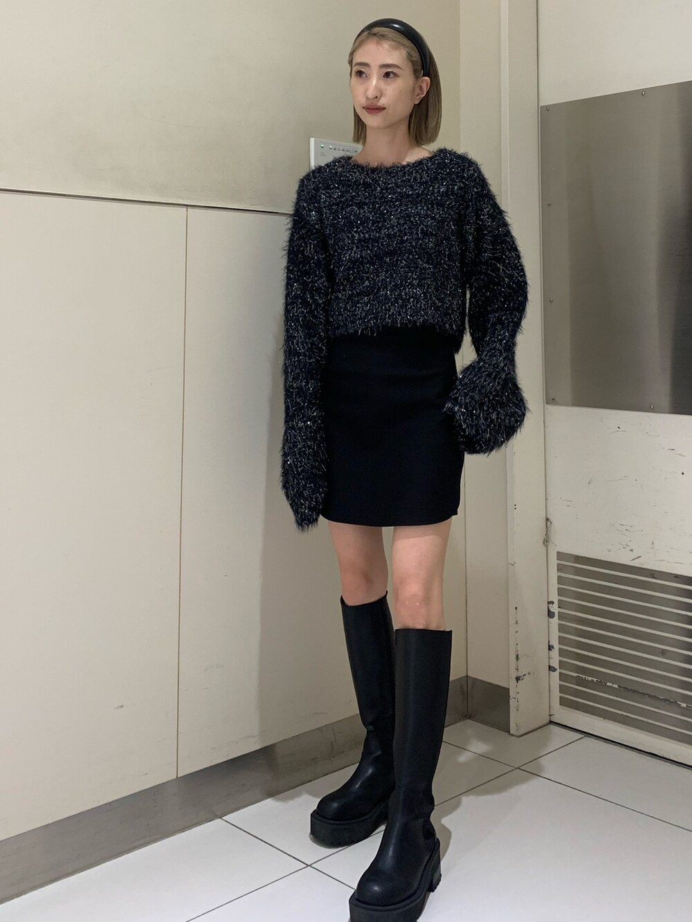 ブラック系のニット/セーター、ブラック系のスカート、ブラック系のブーツを着用したレディースの秋コーディネートの2枚目の写真