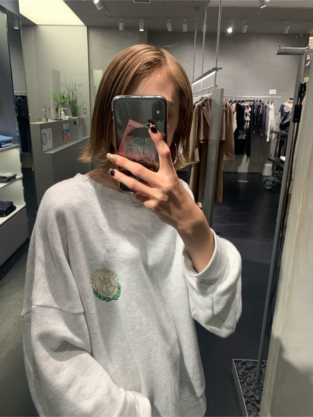 グレー系のスウェット、ブルー系のスカート、ブラック系のブーツを着用したレディースの秋コーディネートの3枚目の写真