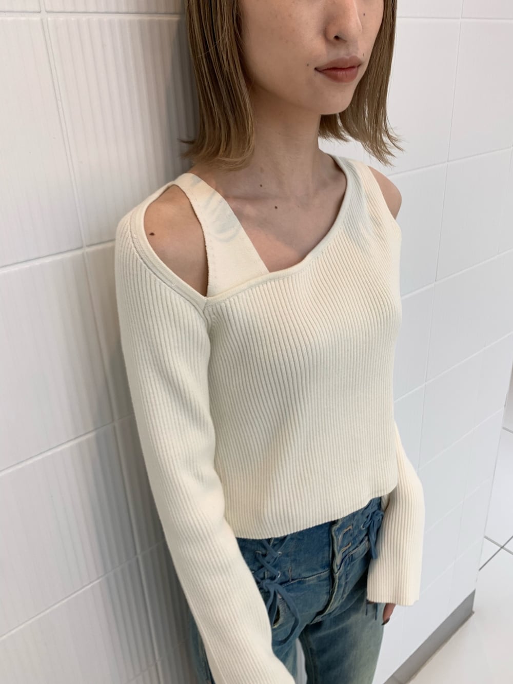 ブラック系のショルダーバッグ、ホワイト系のニット/セーター、ブラック系のブーツを着用したレディースの冬コーディネートの5枚目の写真