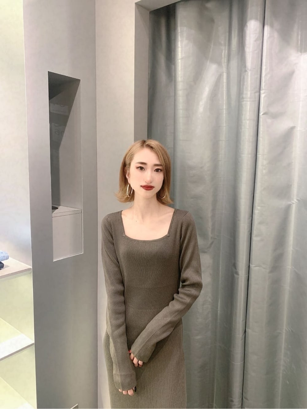 ブラック系のブーツ、グレー系のワンピース、ゴールド系のピアス（両耳用）を着用したレディースの秋コーディネートの7枚目の写真