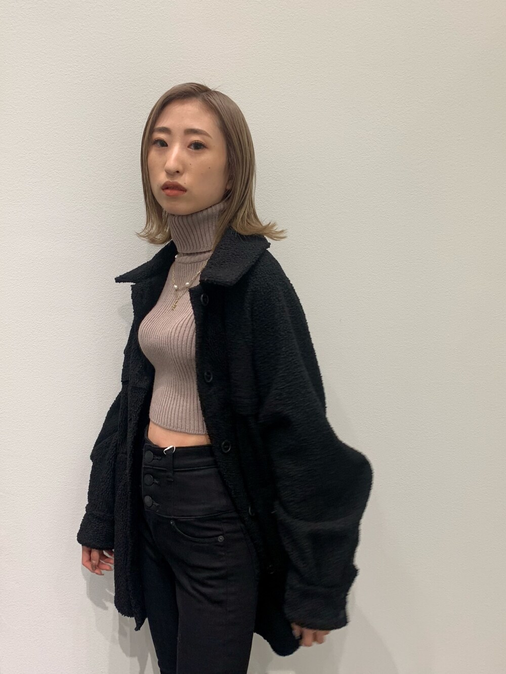 ベージュ系のニット/セーター、ブラック系のブルゾン、ブラック系のデニムパンツを着用したレディースの冬コーディネートの10枚目の写真