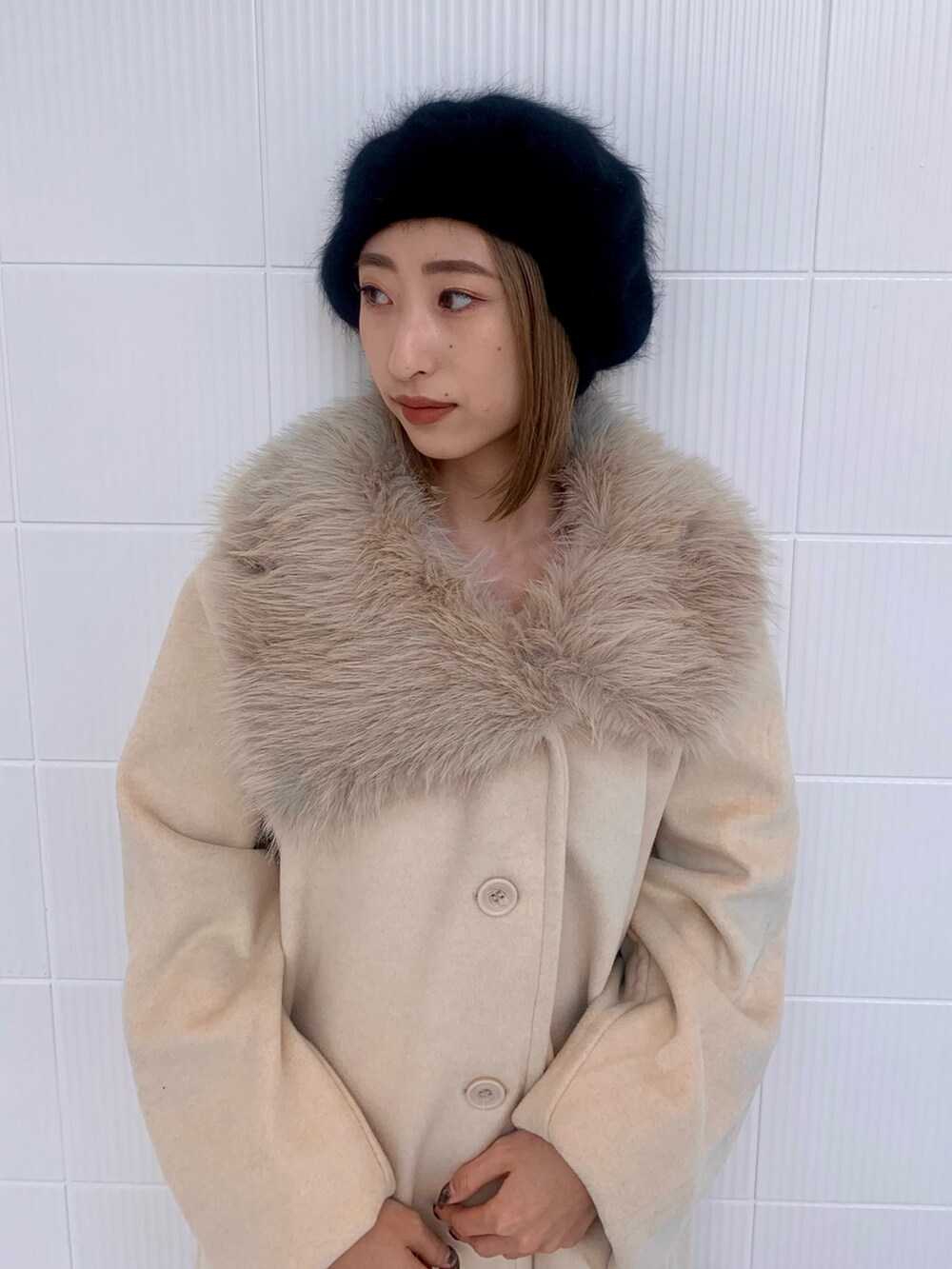 ホワイト系のピーコート、その他のブーツ、ブラック系のハンチング/ベレー帽を着用したレディースの冬コーディネートの3枚目の写真