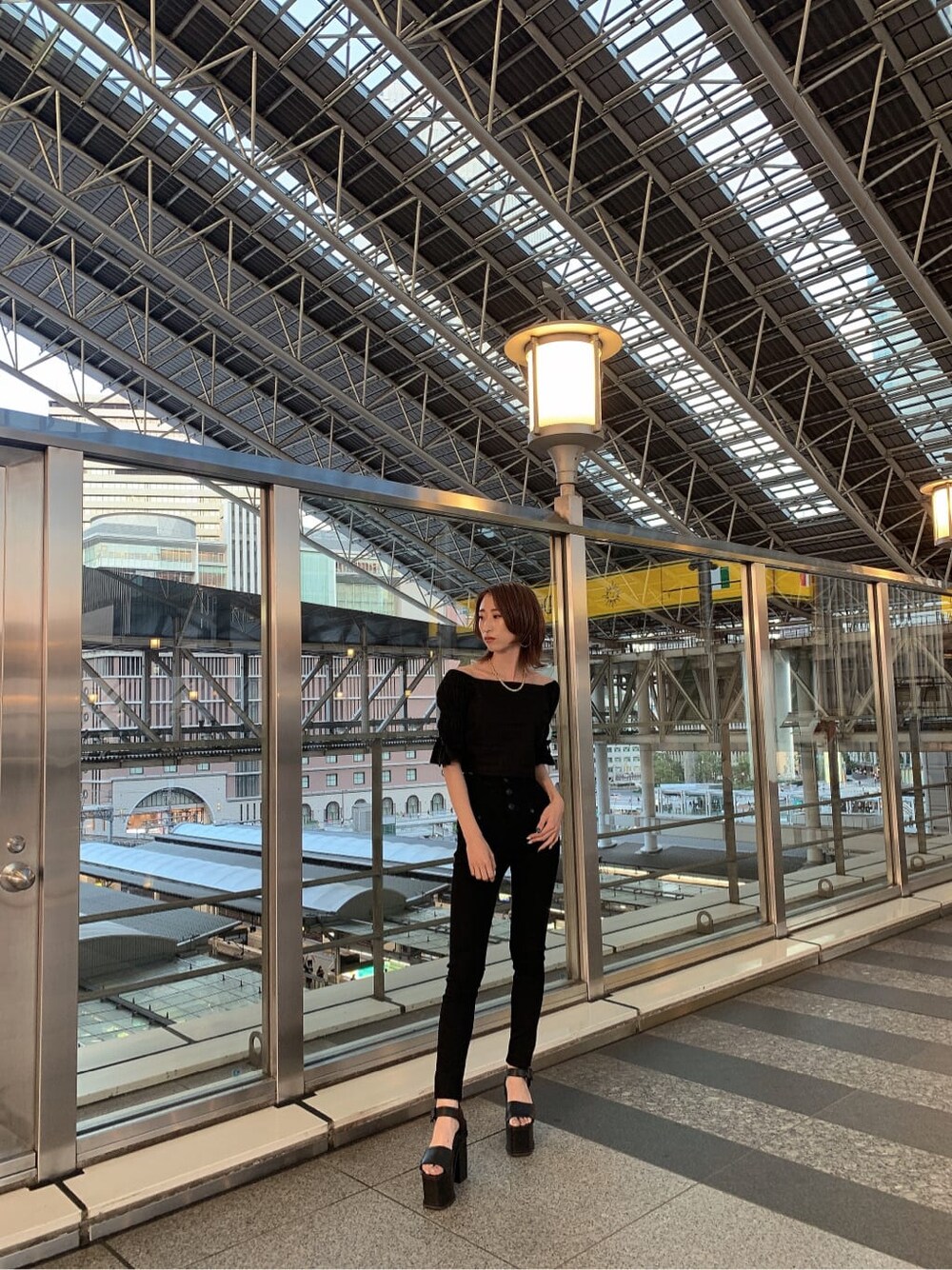 ブラック系のデニムパンツ、ブラック系のサンダル、ブラック系のシャツ/ブラウスを着用したレディースの夏コーディネートの2枚目の写真