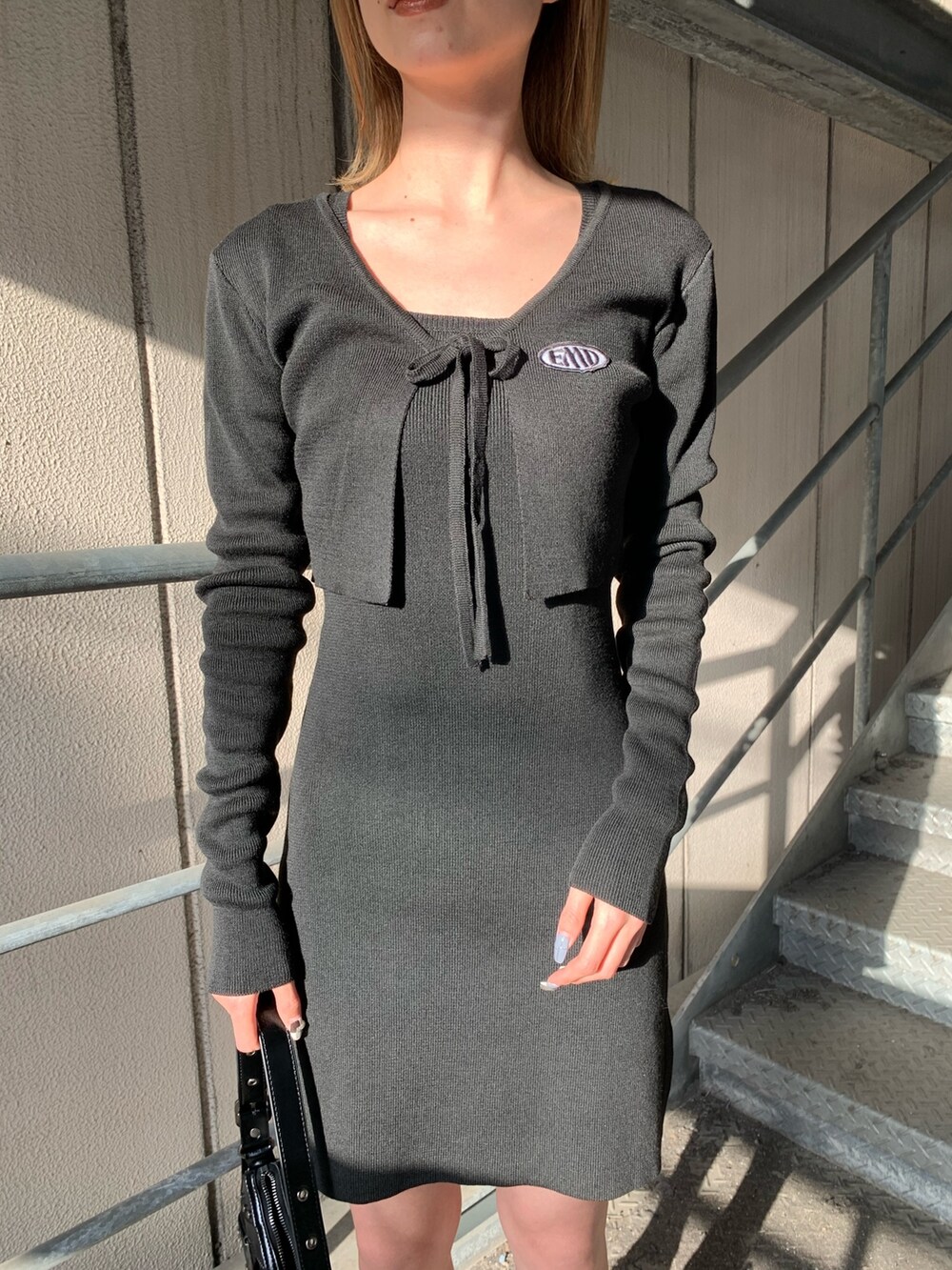 ブラック系のワンピース、ブラック系のサンダル、ブラック系のハンドバッグを着用したレディースの春コーディネートの4枚目の写真