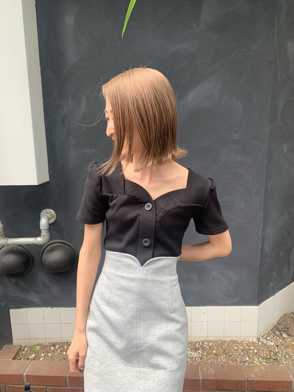 ブラック系のTシャツ/カットソー、グレー系のスカート、ブラック系のサンダルを着用したレディースの春コーディネートの5枚目の写真