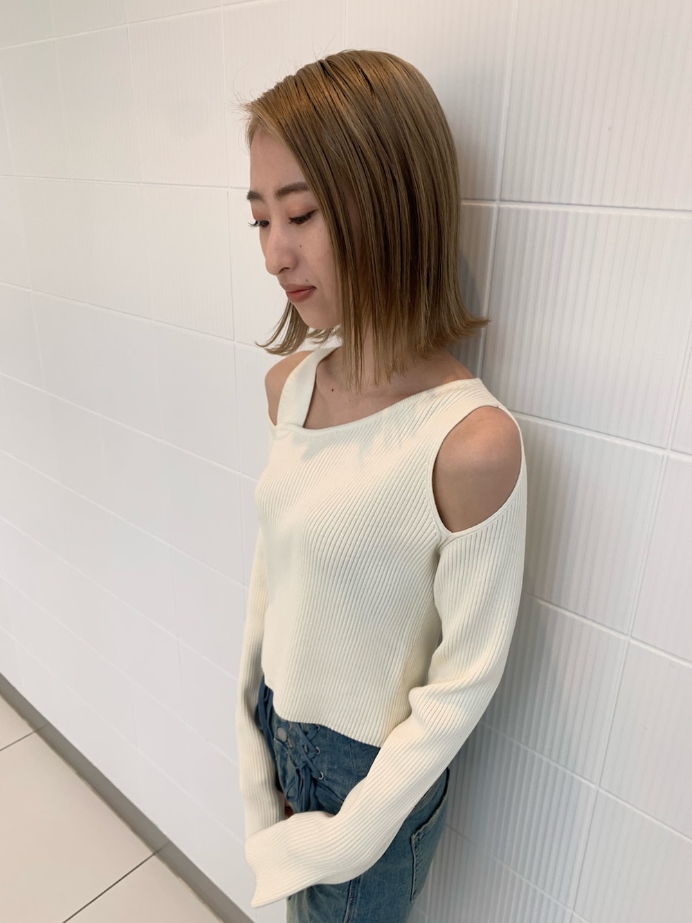 ブラック系のショルダーバッグ、ホワイト系のニット/セーター、ブラック系のブーツを着用したレディースの冬コーディネートの6枚目の写真