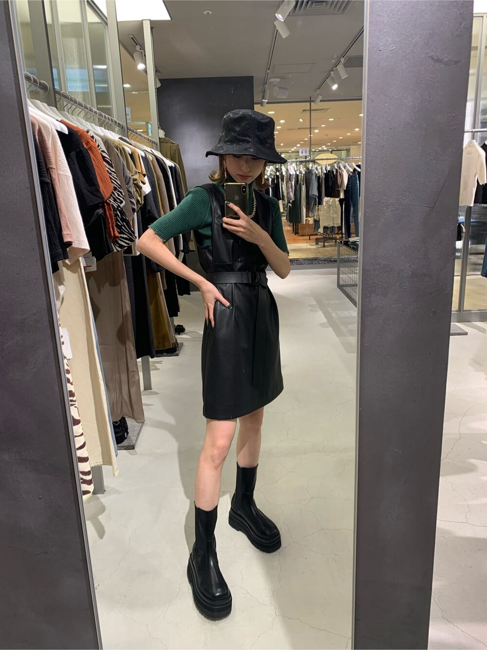 ブラック系のワンピース、グリーン系のニット/セーター、ブラック系のハットを着用したレディースの夏コーディネートの3枚目の写真