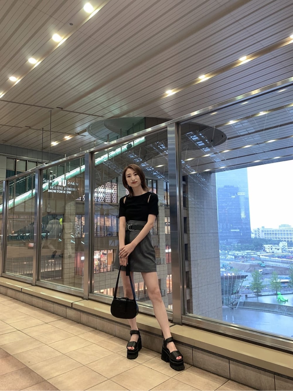 グレー系のスカート、ブラック系のサンダル、ブラック系のハンドバッグを着用したレディースの夏コーディネートの3枚目の写真