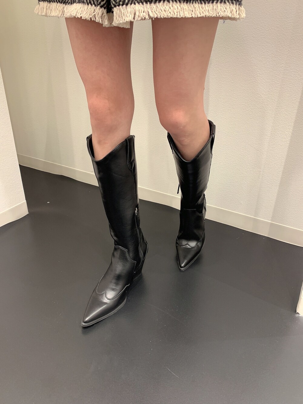 ブラック系のニット/セーター、ブラック系のブーツを着用したレディースの冬コーディネートの8枚目の写真