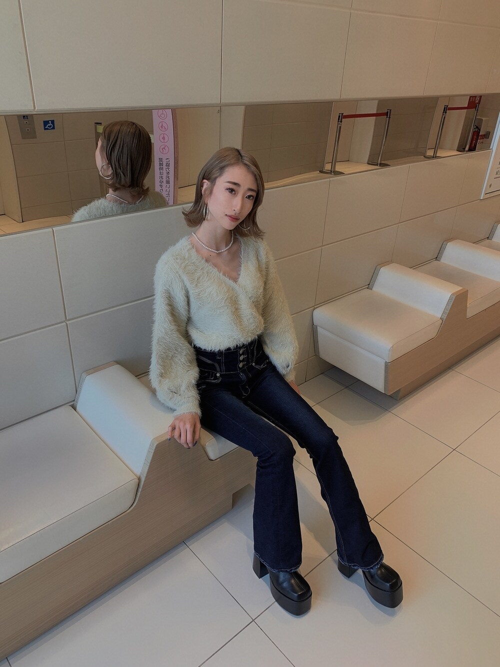 グレー系のニット/セーター、ブルー系のデニムパンツ、ブラック系のブーツを着用したレディースの冬コーディネートの4枚目の写真