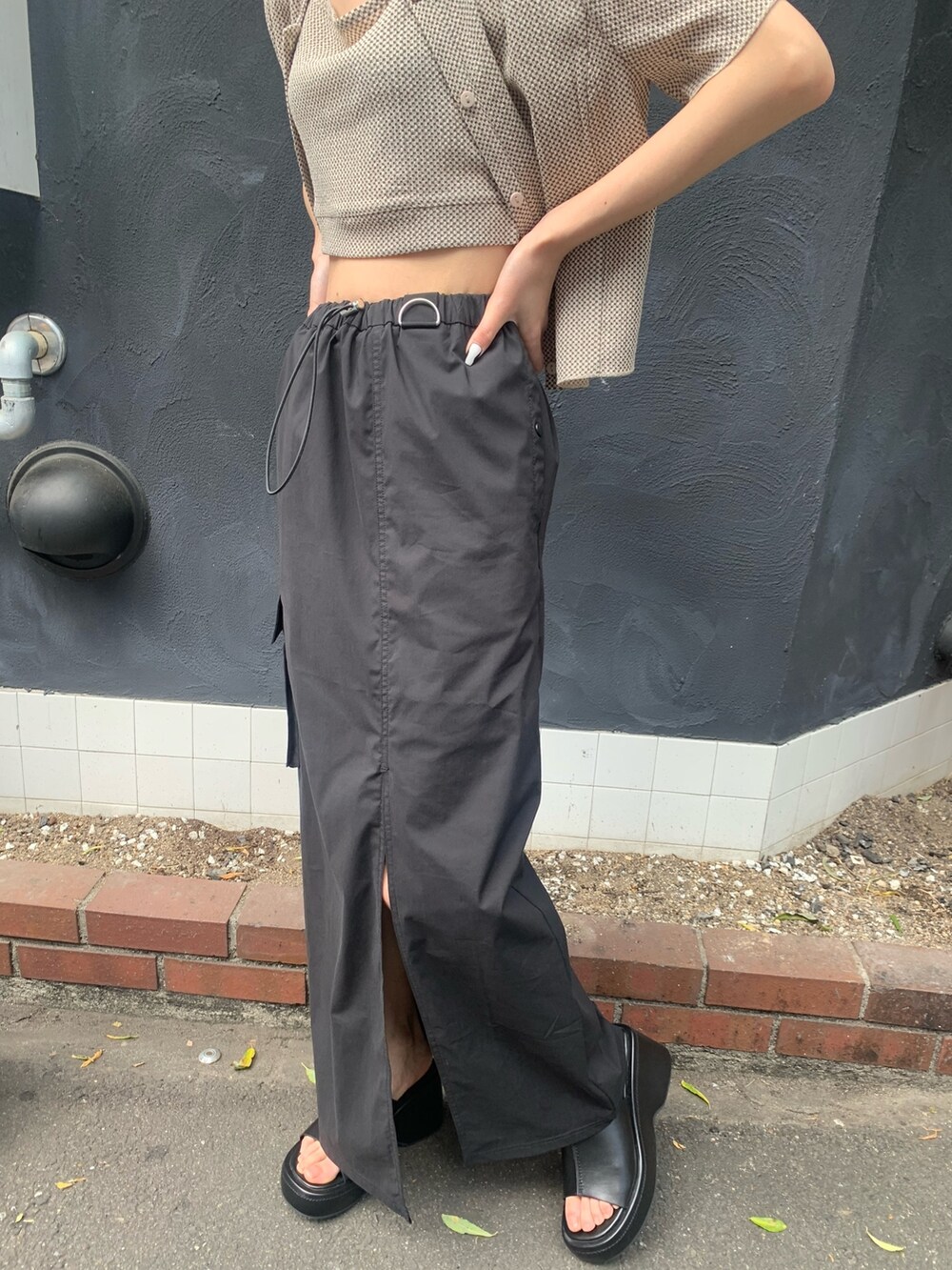 その他のアンサンブル、ブラック系のスカート、ブラック系のサンダルを着用したレディースの春コーディネートの7枚目の写真