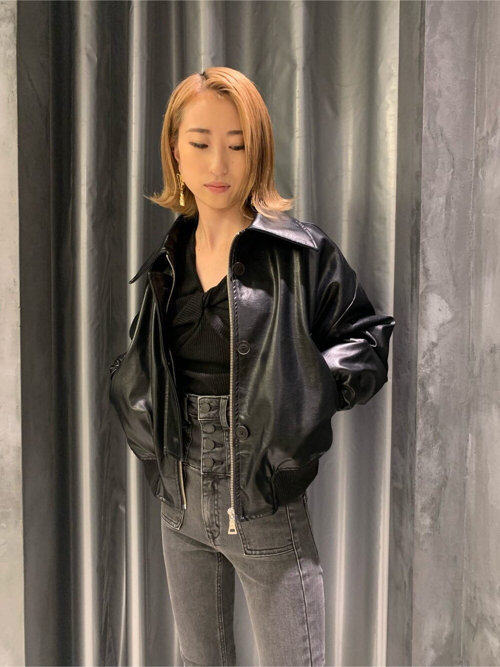 ブラック系のブーツ、グレー系のデニムパンツ、ブラック系のブルゾンを着用したレディースの秋コーディネートの3枚目の写真