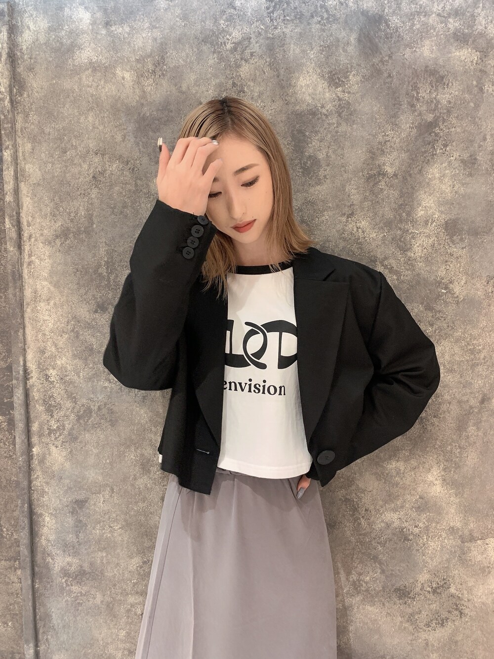 ブラック系のテーラードジャケット、ホワイト系のTシャツ/カットソー、グレー系のスカートを着用したレディースの冬コーディネートの6枚目の写真