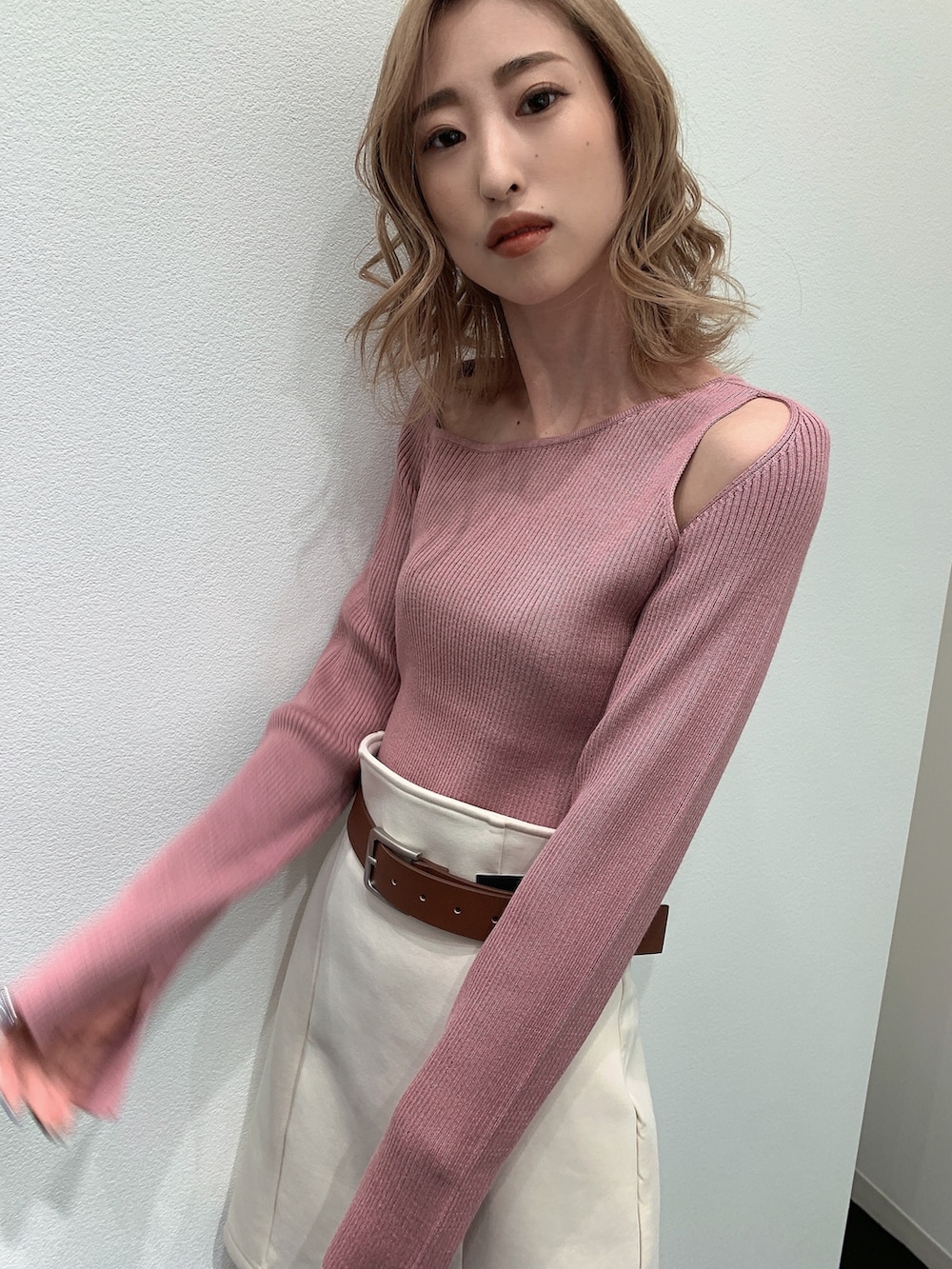 ブルー系のデニムジャケット、ピンク系のニット/セーター、ホワイト系のスカートを着用したレディースの春コーディネートの7枚目の写真