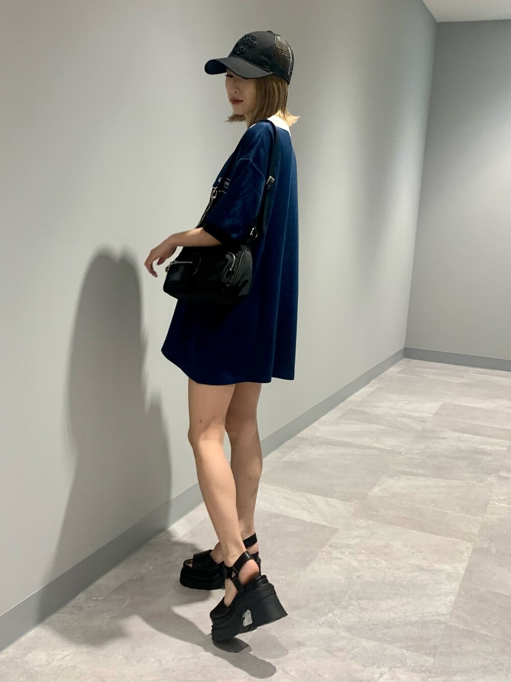 ブルー系のTシャツ/カットソー、ブラック系のハンドバッグ、ブラック系のサンダルを着用したレディースの夏コーディネートの3枚目の写真