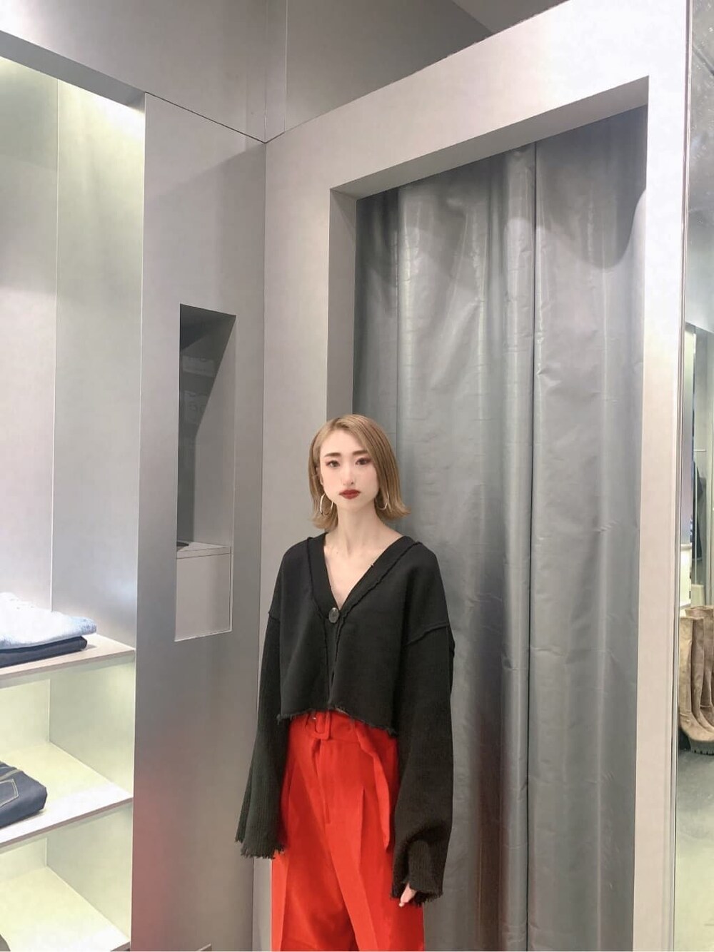 ブラック系のカーディガン/ボレロ、レッド系のその他パンツ、ブラック系のブーツを着用したレディースの秋コーディネートの7枚目の写真