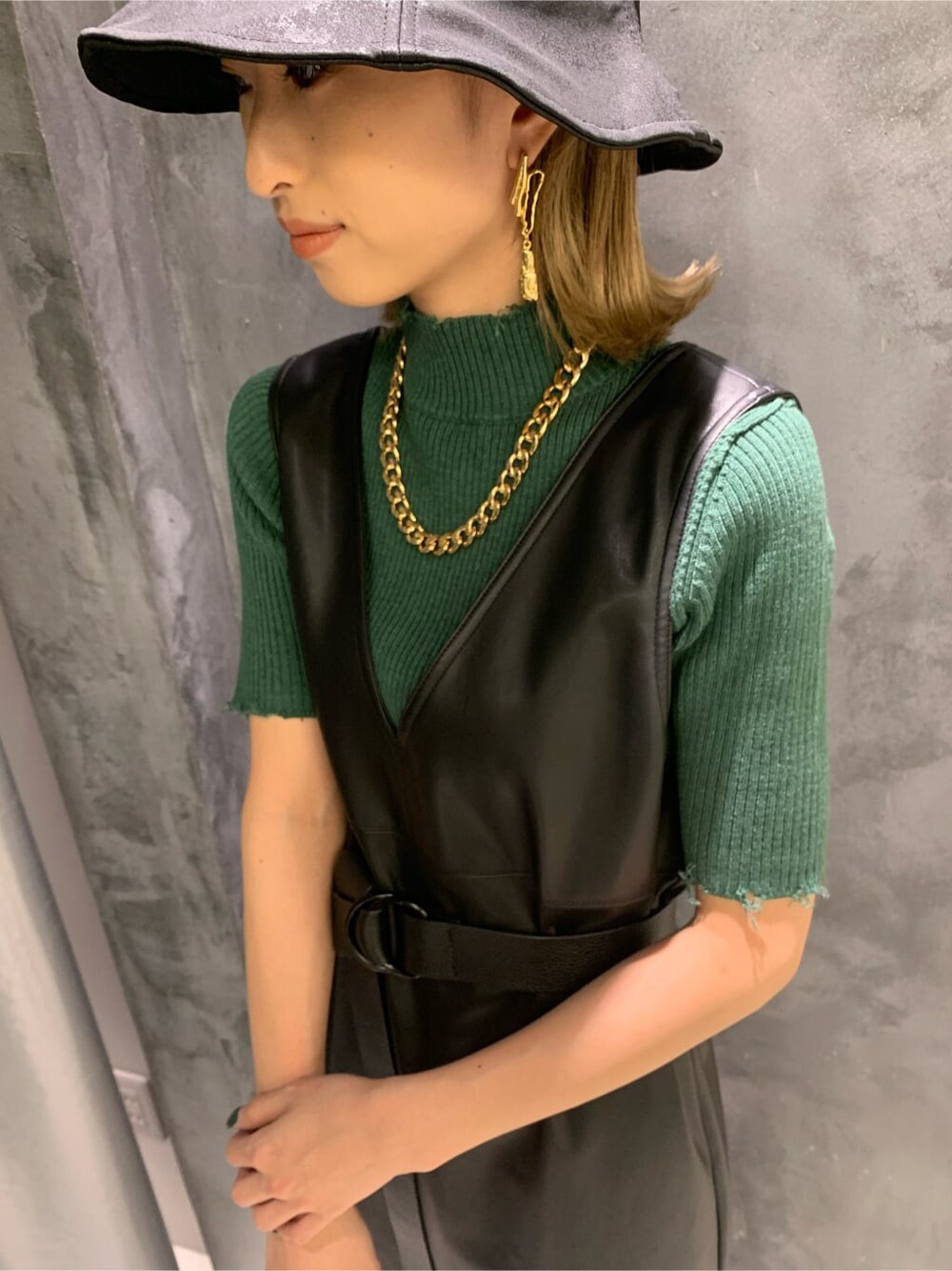 ブラック系のワンピース、グリーン系のニット/セーター、ブラック系のハットを着用したレディースの夏コーディネートの5枚目の写真