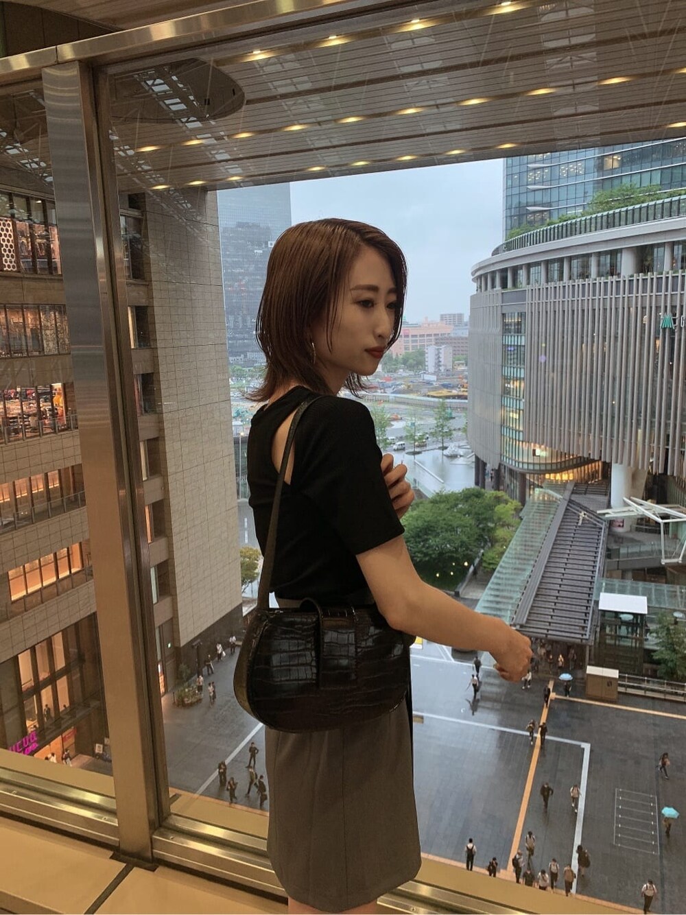 グレー系のスカート、ブラック系のサンダル、ブラック系のハンドバッグを着用したレディースの夏コーディネートの4枚目の写真