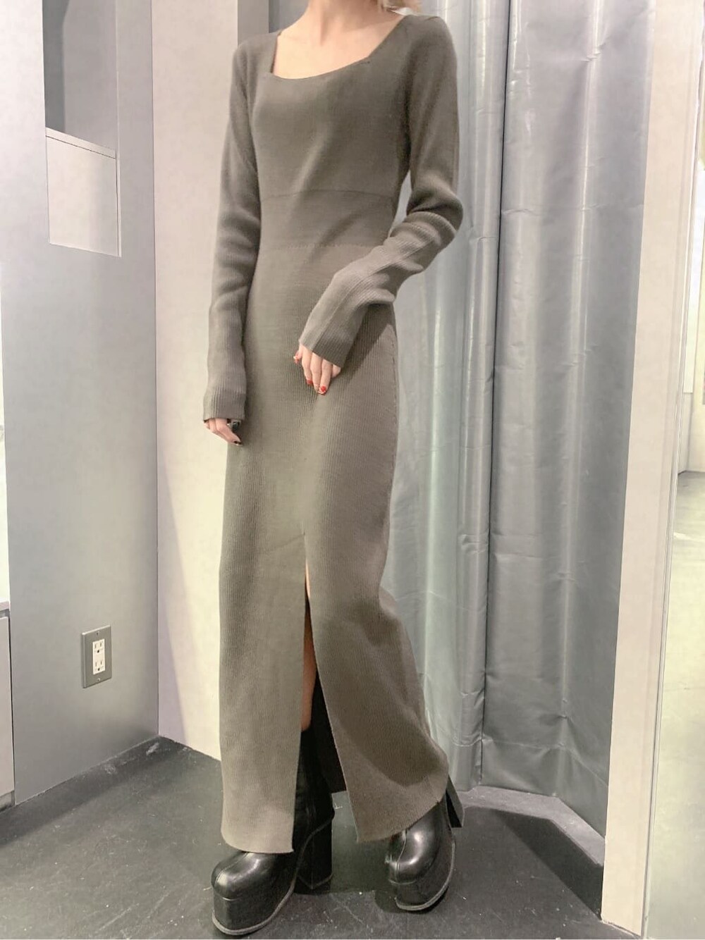 ブラック系のブーツ、グレー系のワンピース、ゴールド系のピアス（両耳用）を着用したレディースの秋コーディネートの10枚目の写真