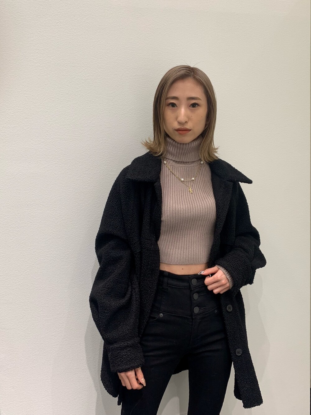 ベージュ系のニット/セーター、ブラック系のブルゾン、ブラック系のデニムパンツを着用したレディースの冬コーディネートの8枚目の写真