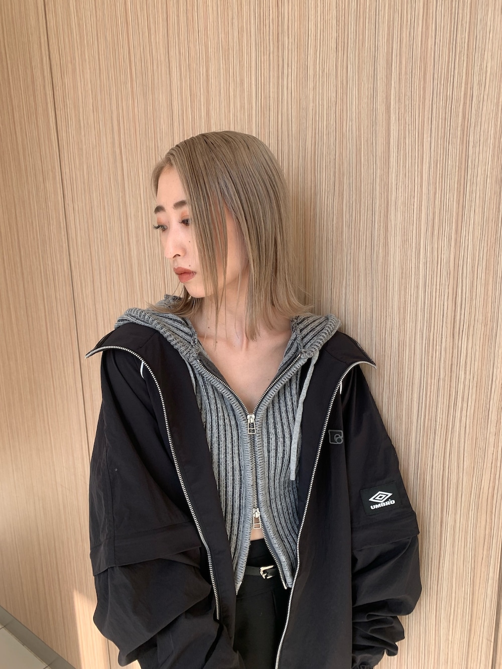 ブラック系のスカート、グレー系のワンピース、ブラック系のブルゾンを着用したレディースの春コーディネートの6枚目の写真