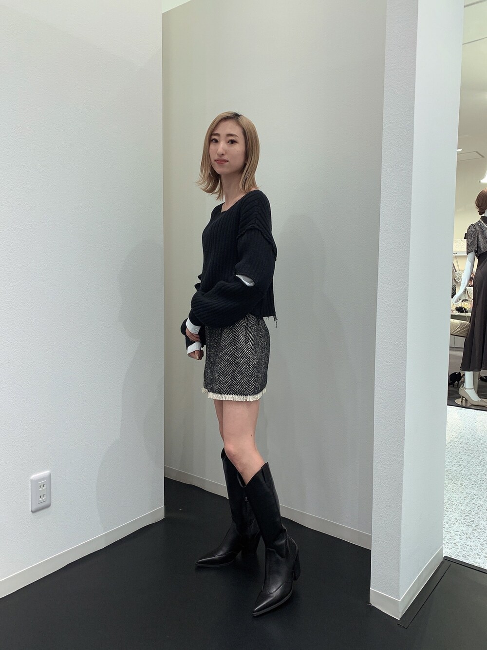 ブラック系のニット/セーター、ブラック系のブーツを着用したレディースの冬コーディネートの2枚目の写真