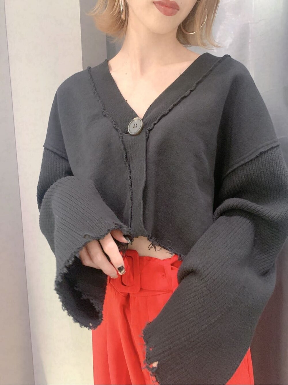 ブラック系のカーディガン/ボレロ、レッド系のその他パンツ、ブラック系のブーツを着用したレディースの秋コーディネートの6枚目の写真