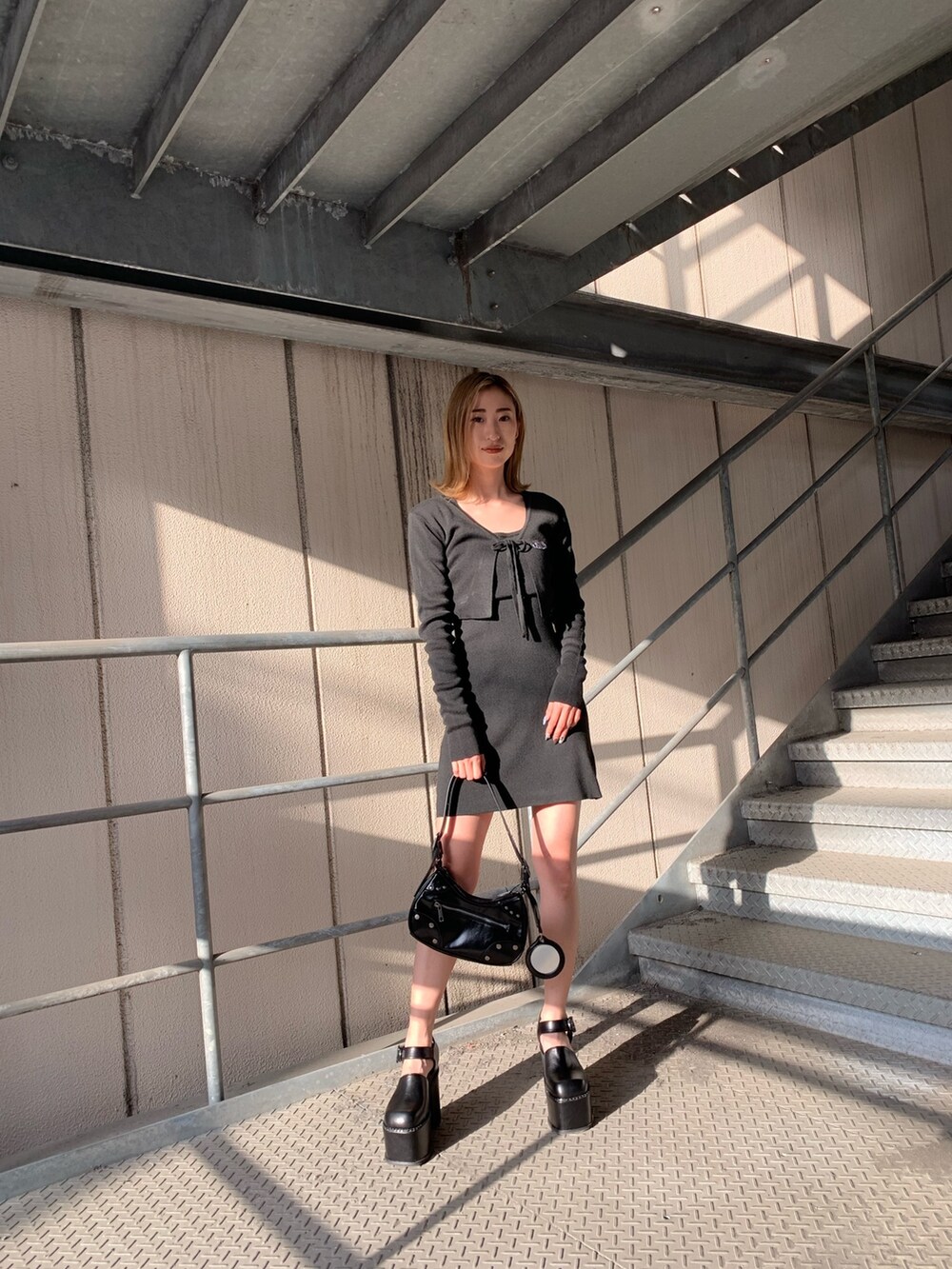 ブラック系のワンピース、ブラック系のサンダル、ブラック系のハンドバッグを着用したレディースの春コーディネートの3枚目の写真