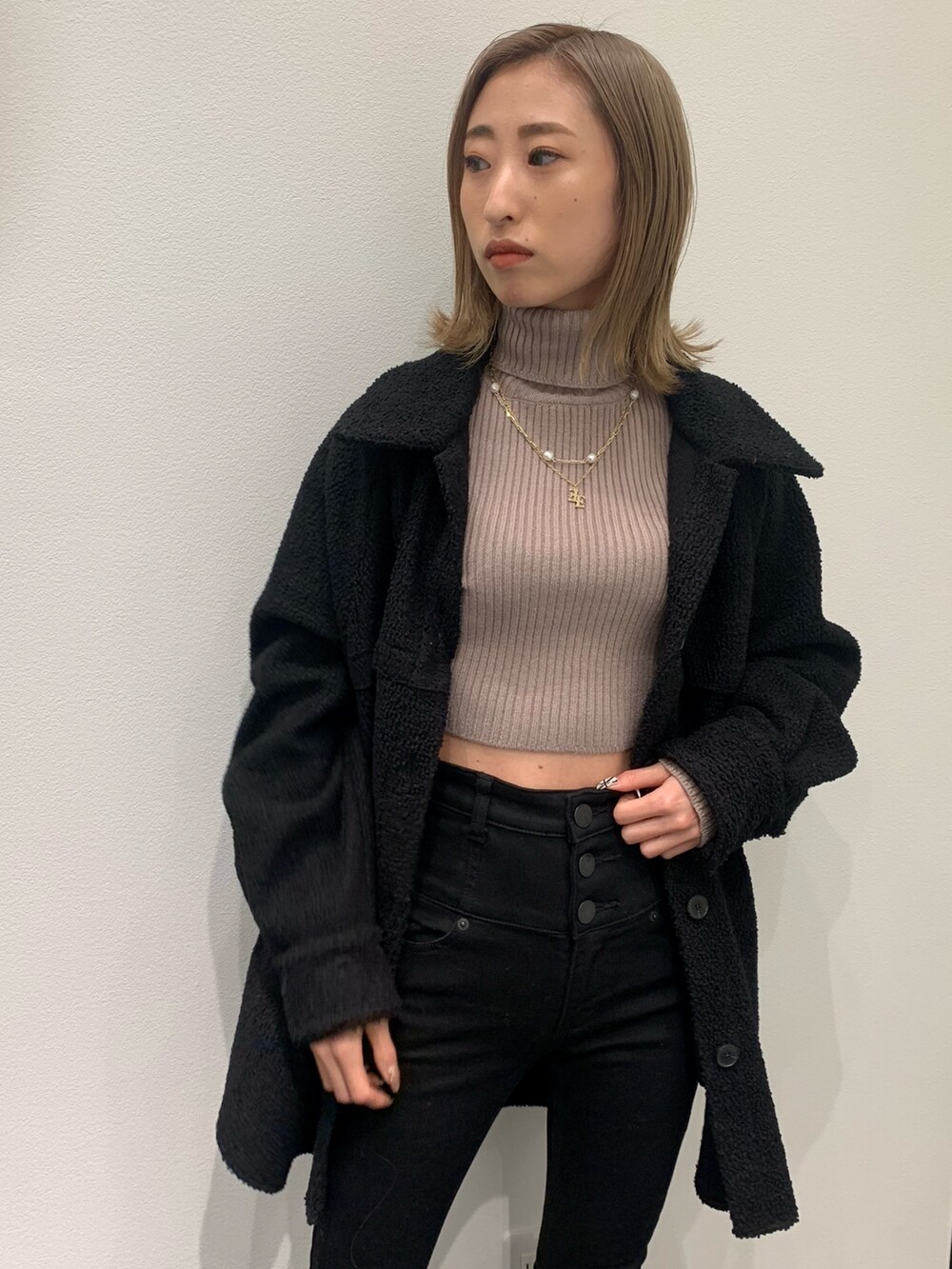 ベージュ系のニット/セーター、ブラック系のブルゾン、ブラック系のデニムパンツを着用したレディースの冬コーディネートの7枚目の写真