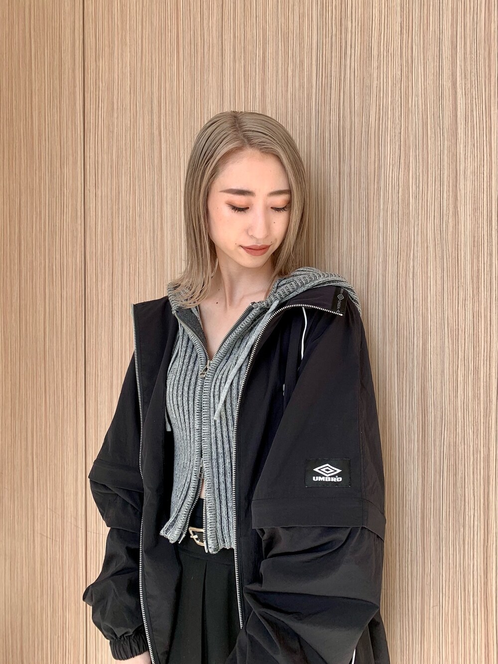 ブラック系のスカート、グレー系のワンピース、ブラック系のブルゾンを着用したレディースの春コーディネートの4枚目の写真